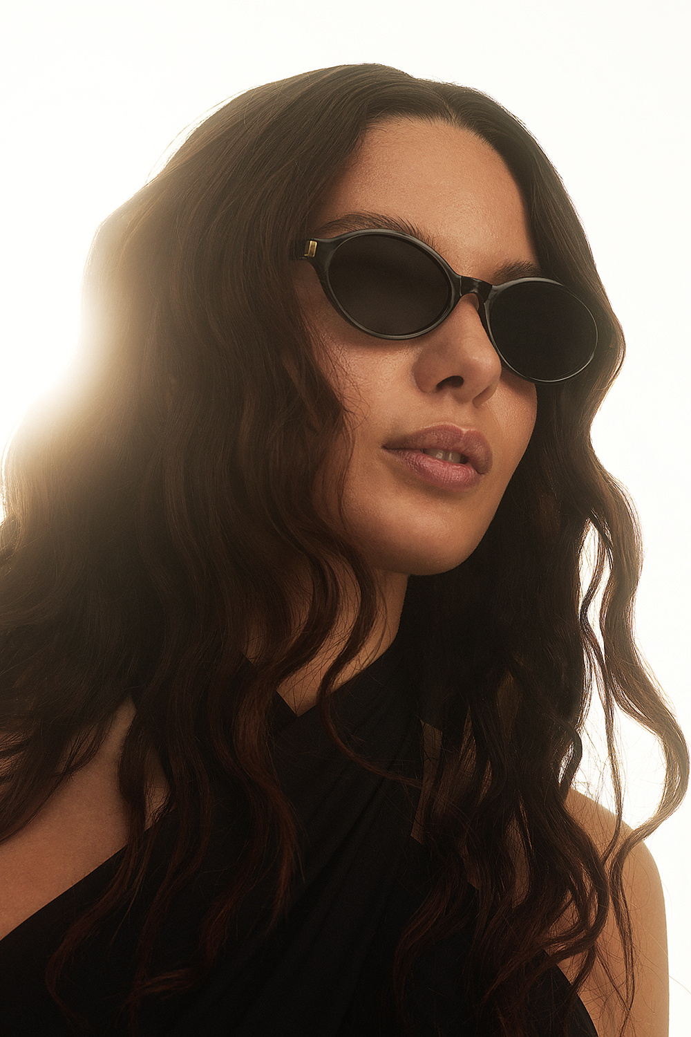 Mustat soikeat aurinkolasit, joissa kullanvärinen yksityiskohta