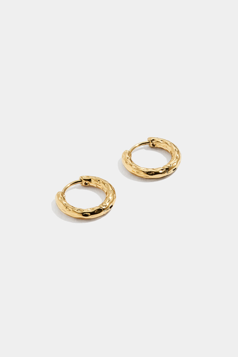 Pienet taotut teräksiset korvarenkaat, joissa on 18 karaatin kultaus