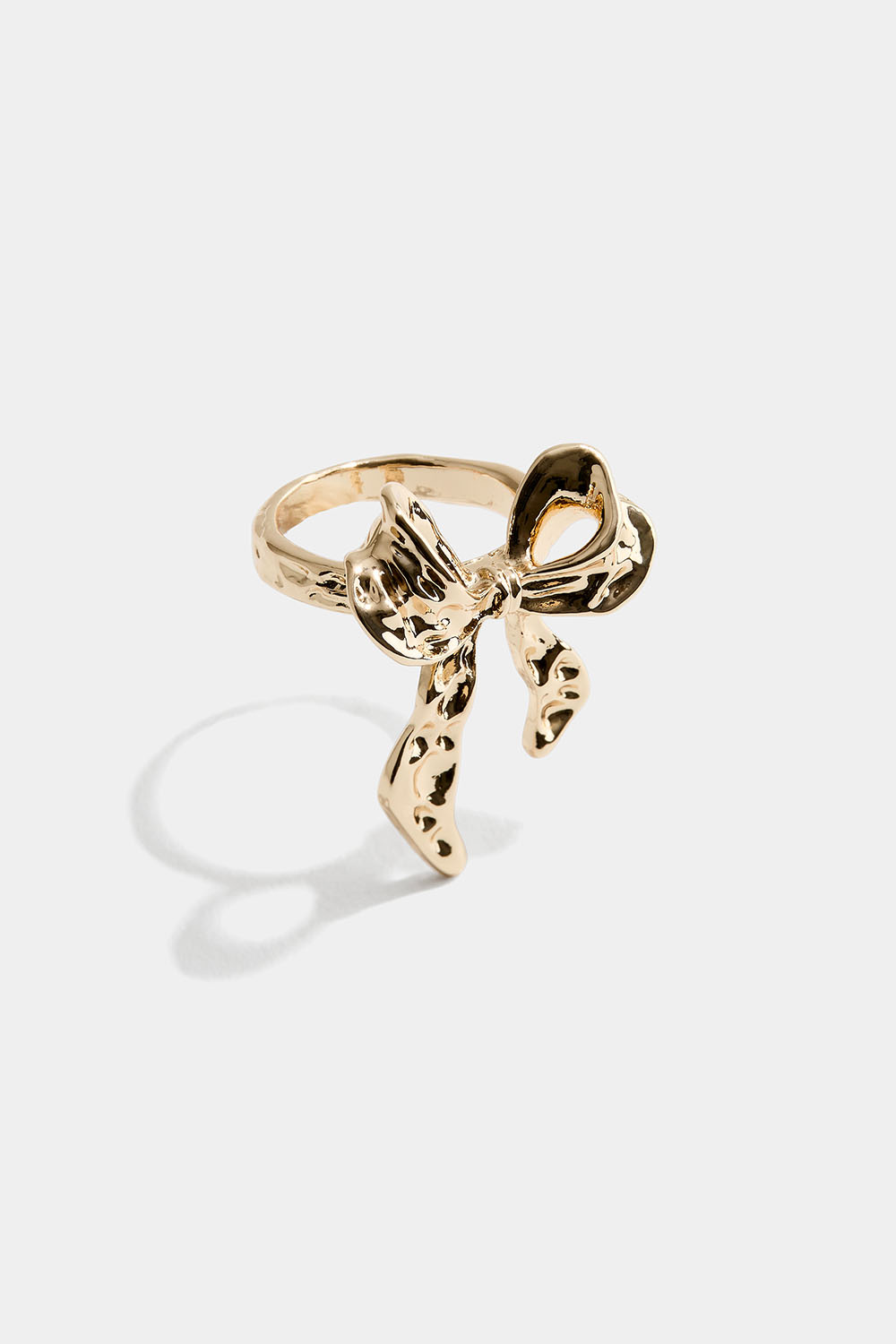 Kullanvärinen sormus, jossa on vasaroitu rusetti