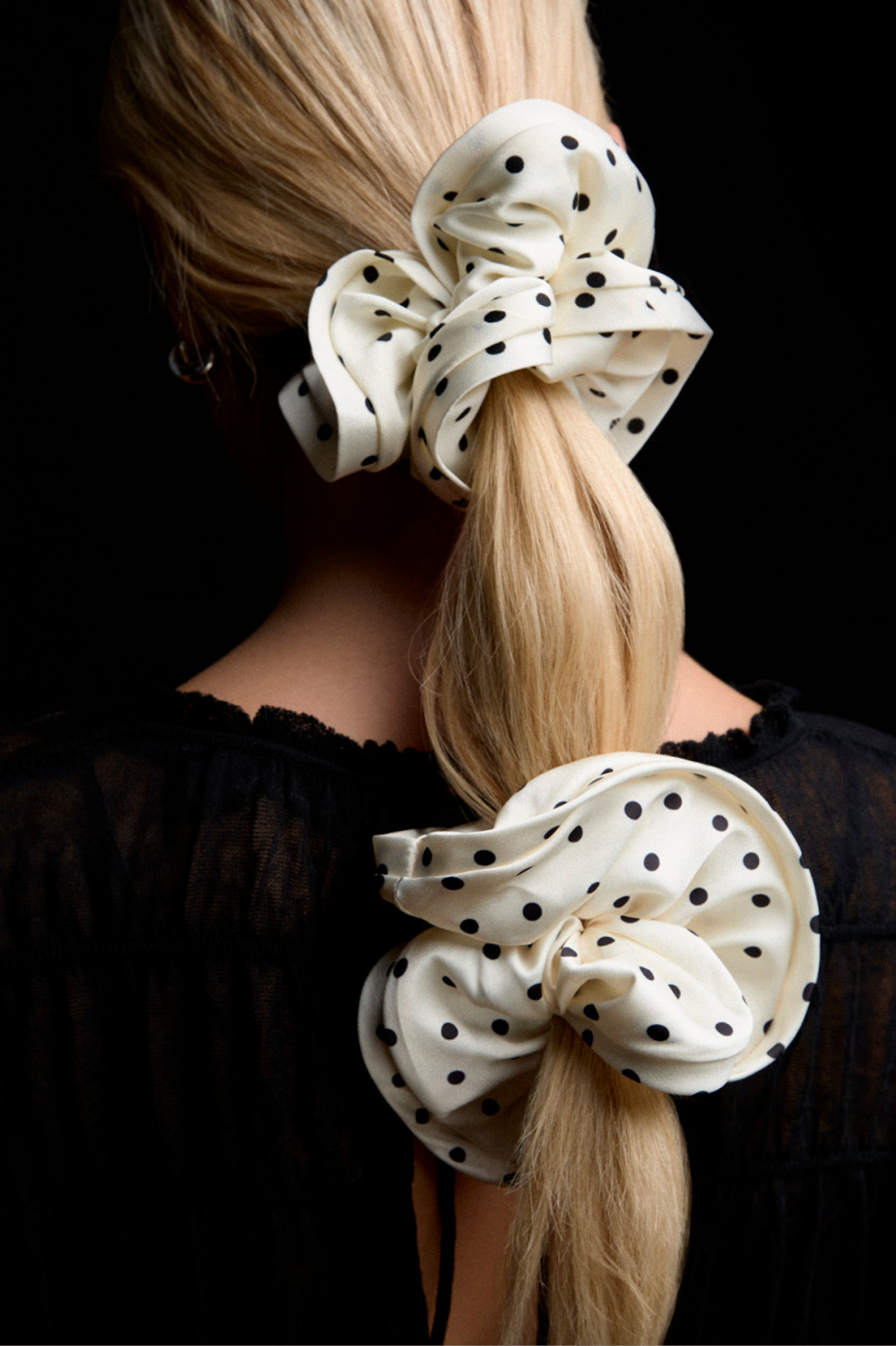 Pilkullinen hiusdonitsi valkoista keinosilkkiä